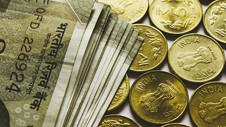 A close up shot of Indian currency notes and coins