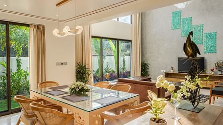 A contemporary dining area featuring a large wooden table, stylish chairs, and abundant natural light streaming through the windows.