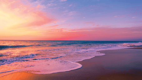 different hues in the sky after a sunset on the beach with waves overlapping