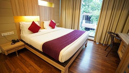 an image of a close up shot of a bed in a suite with wooden flooring at  City Centre Residency, Bangalore