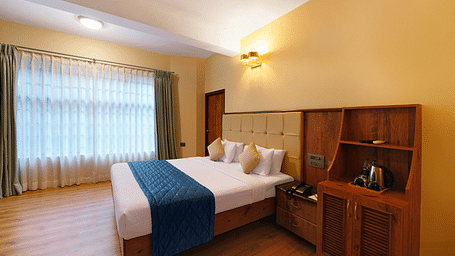 A room in bengaluru with large windows, a queen size bed, and wooden decor - Cross Roads Inn, Bengaluru