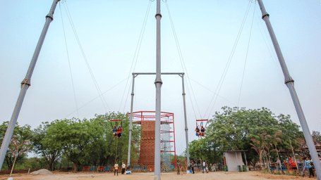 A massive giant swing structure towers over visitors in an outdoor arena - District Gravity Adventure Park, Hyderabad