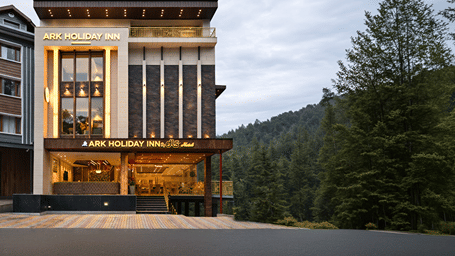 Exterior view of modern hotel building surrounded by lush pine trees at DLS Ark Holiday Inn, Dalhousie.   