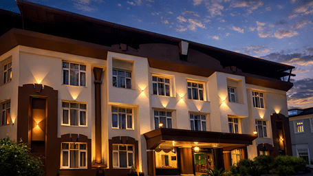 Facade of DLS Pearl Mussoorie, Haridwar featuring a well lit building with windows and balconies.