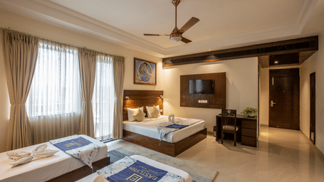 A spacious executive room featuring a king bed and a single bed with views of the modern room amenities — Eastlynn Resort, Rishikesh