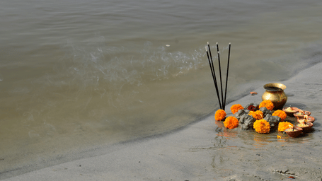 Offerings with incense sticks and flowers placed by a riverbank during Aadi Perukku rituals, symbolising gratitude to water and prosperity