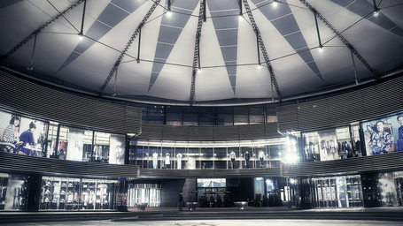 A striking modern mall interior with a domed glass ceiling, illuminated storefronts, and a sleek, spacious central walkway, symbolising Phoenix Marketcity Pune.