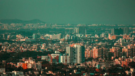 An overview of the city of Pune with high rise and small buildings in view during daylight.