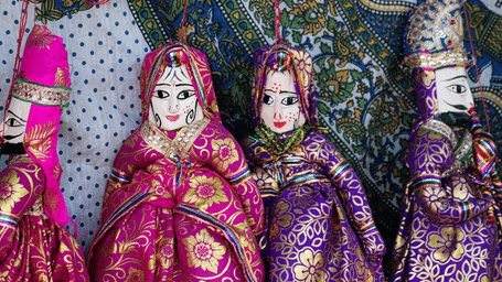 Close-up of traditional Rajasthani Kathputli string puppets dressed in colourful, embroidered folk costumes.