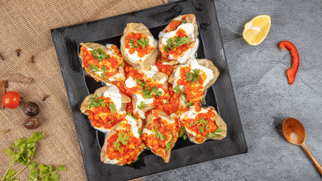A top-down view of a chaat preparation with curd that is kept on a plate, a Famous Food in Indore.