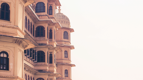 Close-up of a intricately designed windows and balconies of a palace under a clear sky.