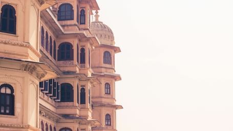 Close-up of a intricately designed windows and balconies of a palace under a clear sky.