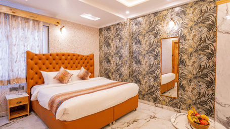 A stylish bedroom featuring a prominent orange tufted headboard and nature-themed wallpaper - Golden Oak By The Lake Hill, Khurpatal