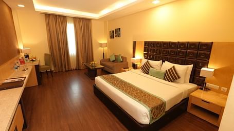 Guest room featuring a large bed and bedside tables - Grand Plaza Lords Inn Jammu