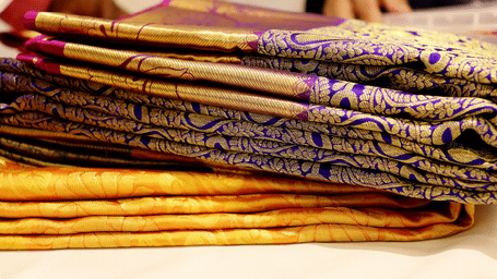 A collection of traditional sarees with intricate patterns and designs in many colours.
