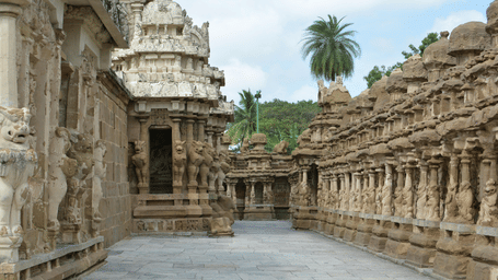 Narrow passage between two ornately carved stone walls of an ancient temple complex.