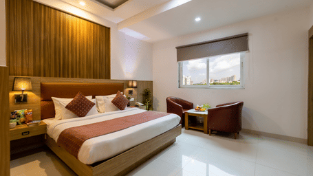 Executive Room at Hotel Corporate Suites featuring a plush bed with a seating space next to the window