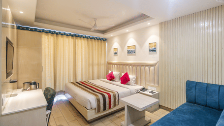 Spacious double room with bed and sofa at Hotel Diamond Plaza, Chandigarh