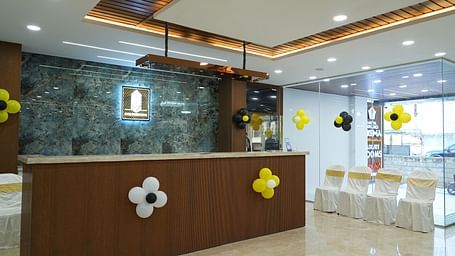 side angle view of the reception area with four chairs kept in the side - Hotel Grand Sigma