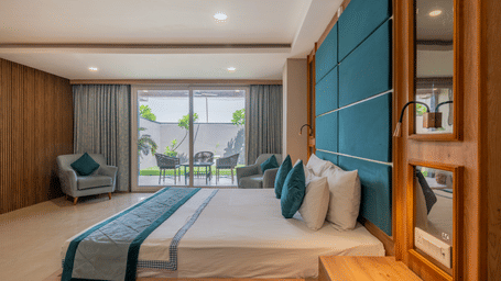 A well-appointed guest room with a large bed and a view of the outside area at Hotel Highway King Shahpura.