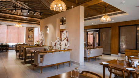 A restaurant featuring wooden dining tables, seating, and a decorative ceiling at Hotel Sonar Bangla, Ajodhya Hills.