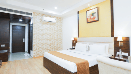 Elegant double bed room with ambient lighting, wall art, and bedside tables at Hyphen Premier Hotel, Meerut.