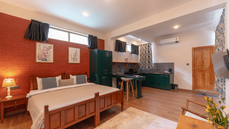 Full view of a studio suite including the bed, seating area, and open-plan kitchenette - Johnson Lodge & Spa, Manali