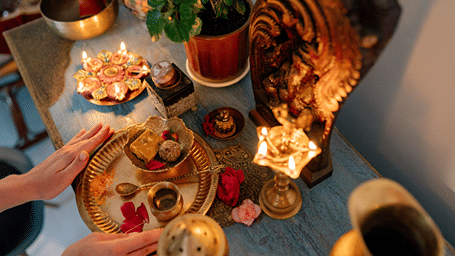 Devotees offering lit lamps and prayers at a Hindu shrine