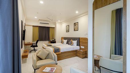 Stylish comfort twin room with soft lighting, seating area, and large bed at Lemonridge Hotels, IDPL Balanagar.