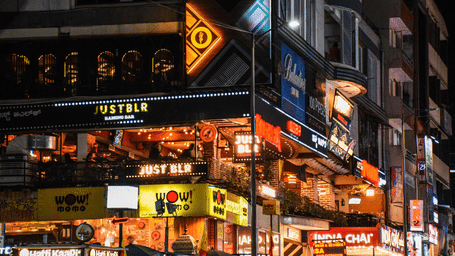 Night view of the busy bustling Church Street in Bengaluru featuring a several dining and commercial outlets established in the surrounding buildings.