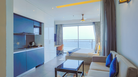 Spacious living area with sofa, table, and large window view in Livbox Supernova, Noida.