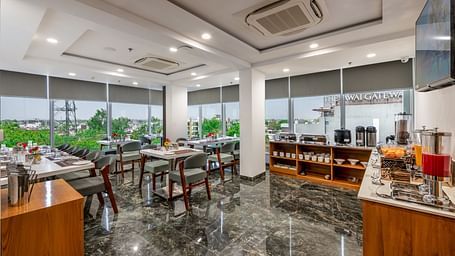 Spacious BCR restaurant dining area with large windows, multiple tables & chairs and the marble flooring.