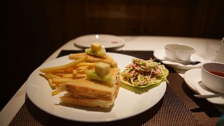 a plate of sandwich, and fries placed on a dining table