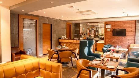 The Lords Inn Udaipur features a stylish dining area with a bar, comfortable seating, and modern decor.