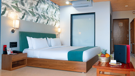 Spacious double room at Lords SKD Resort, Salangpur, with a wooden bedside table and fruit basket.