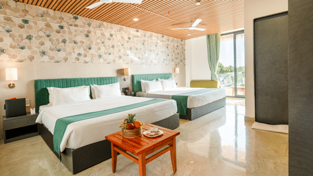 Well-appointed twin bedroom at Lords SKD Resort, Salangpur, featuring marble flooring and a small coffee table.