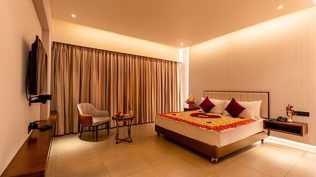 An image of a room featuring a bed adorned with flowers, with a television positioned in front at M Pro Palace.