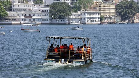 A boat travelling in Lake Pichola towards the city palace - City Palace Udaipur near Hotel