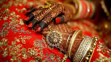 A close up shot of a henna stained hands with bangles