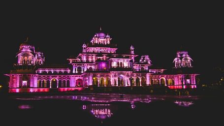 A far out view of a palace with lights on in the night in Jaipur