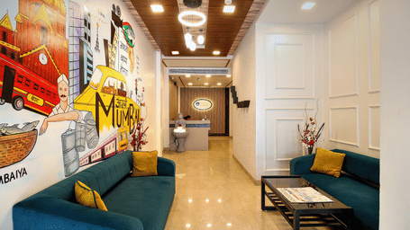 A vibrant lobby with a colorful mural wall representing Mumbai, plush sofas, and a front desk.