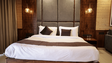 Comfortable king bed in Pine Hollow room with plush bedding and stylish wooden headboard.