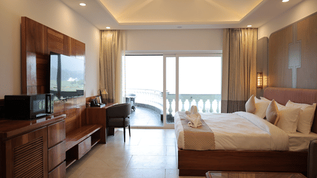 Spacious Soak Sanctuary interior with king bed, seating area, and large windows.