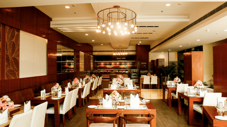 Beautifully arranged tables and chairs inside a luxury hotel fine dining restaurant.