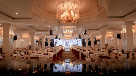 Large, opulent banquet hall set up with tables for a formal event.