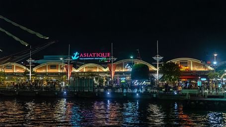Facade view of Asiatique Waterfront with Chao Phraya River in the foreground.