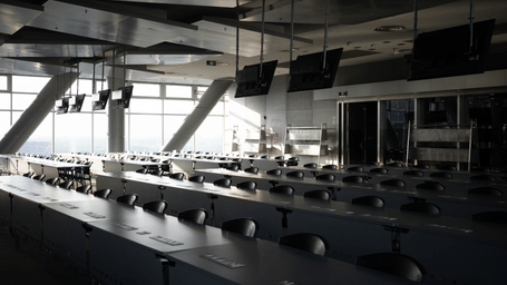 A view of a meeting room inside a building with many chairs and long tables in view inside Queen Sirikit National Convention Center, Bangkok.