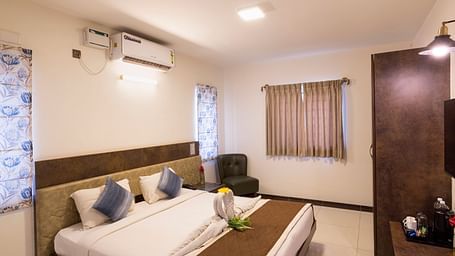 Contemporary bedroom with seating area and air conditioning – Nirantara Resort & Spa