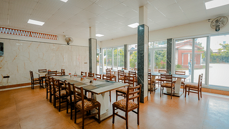 A dining area or event space with long tables and chairs at Nirantara Resort & Spa.