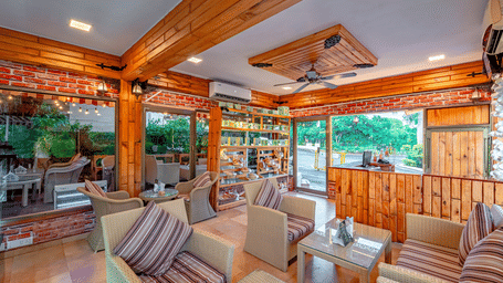 Indoor lounge at Café Latte, located within Noor-Us-Sabah Palace, Bhopal, featuring wicker armchairs with striped cushions and warm wooden interiors.